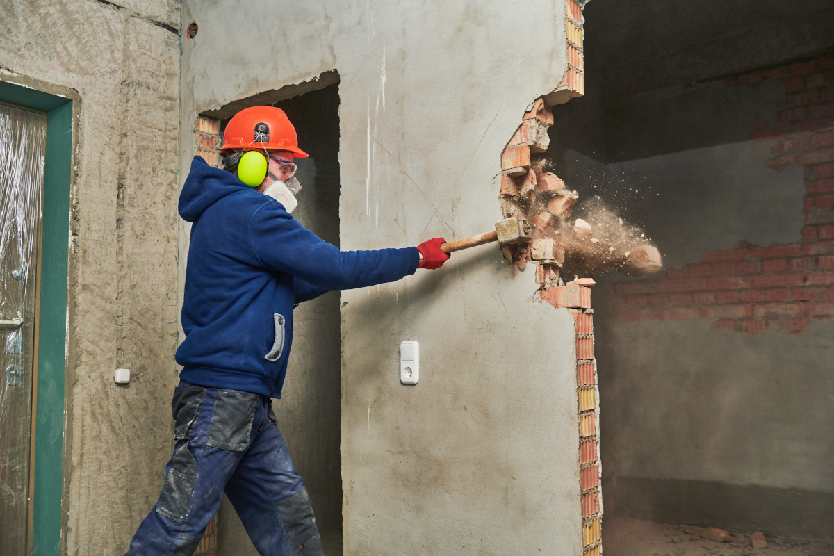 demolition work. Worker builder with sledgehammer destroying interior wall. Rearrangement during renovation. slow motion